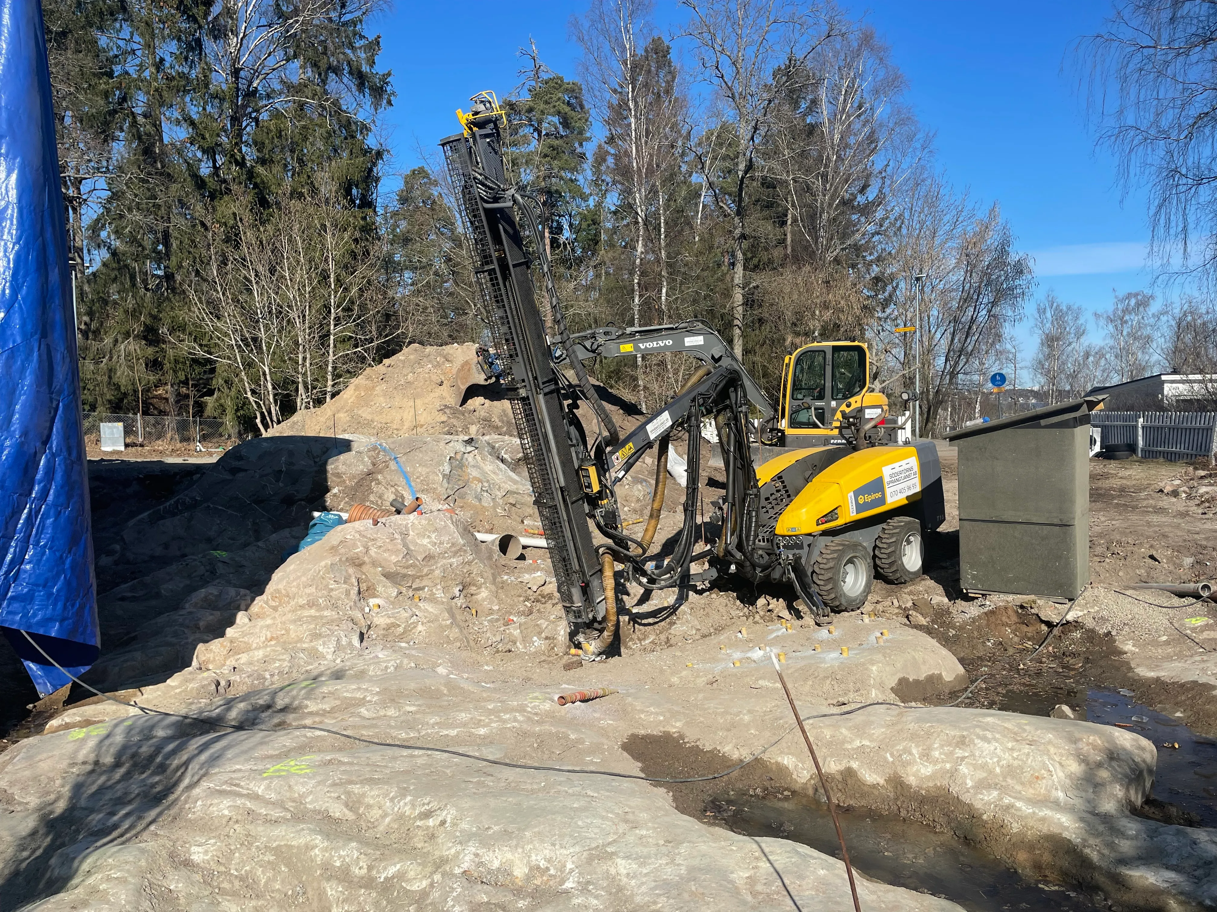 Bergspräckning intill väg och stödmur i tätort