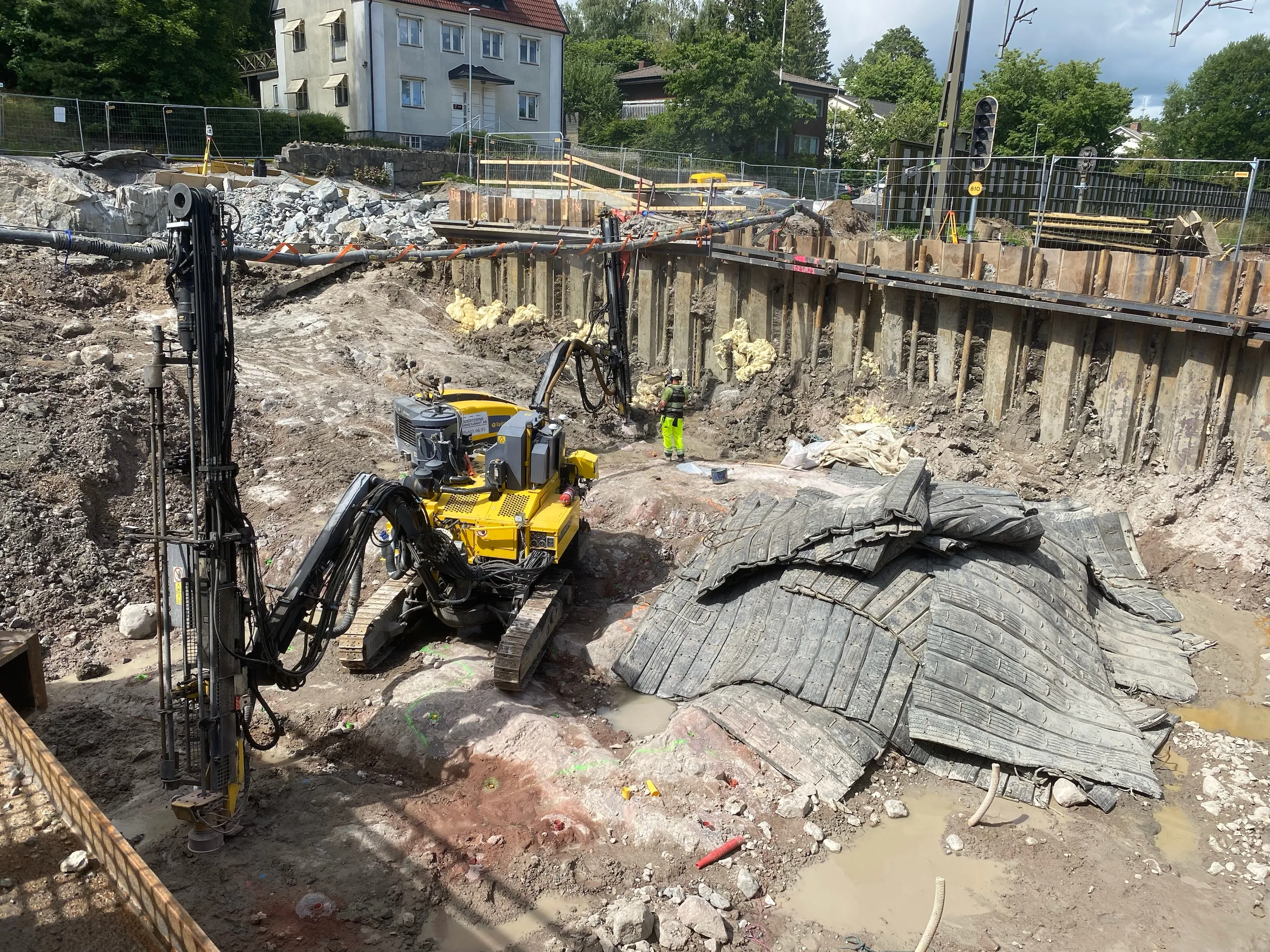 Djup grundläggningsgrop med spont och sprängmattor i tätort