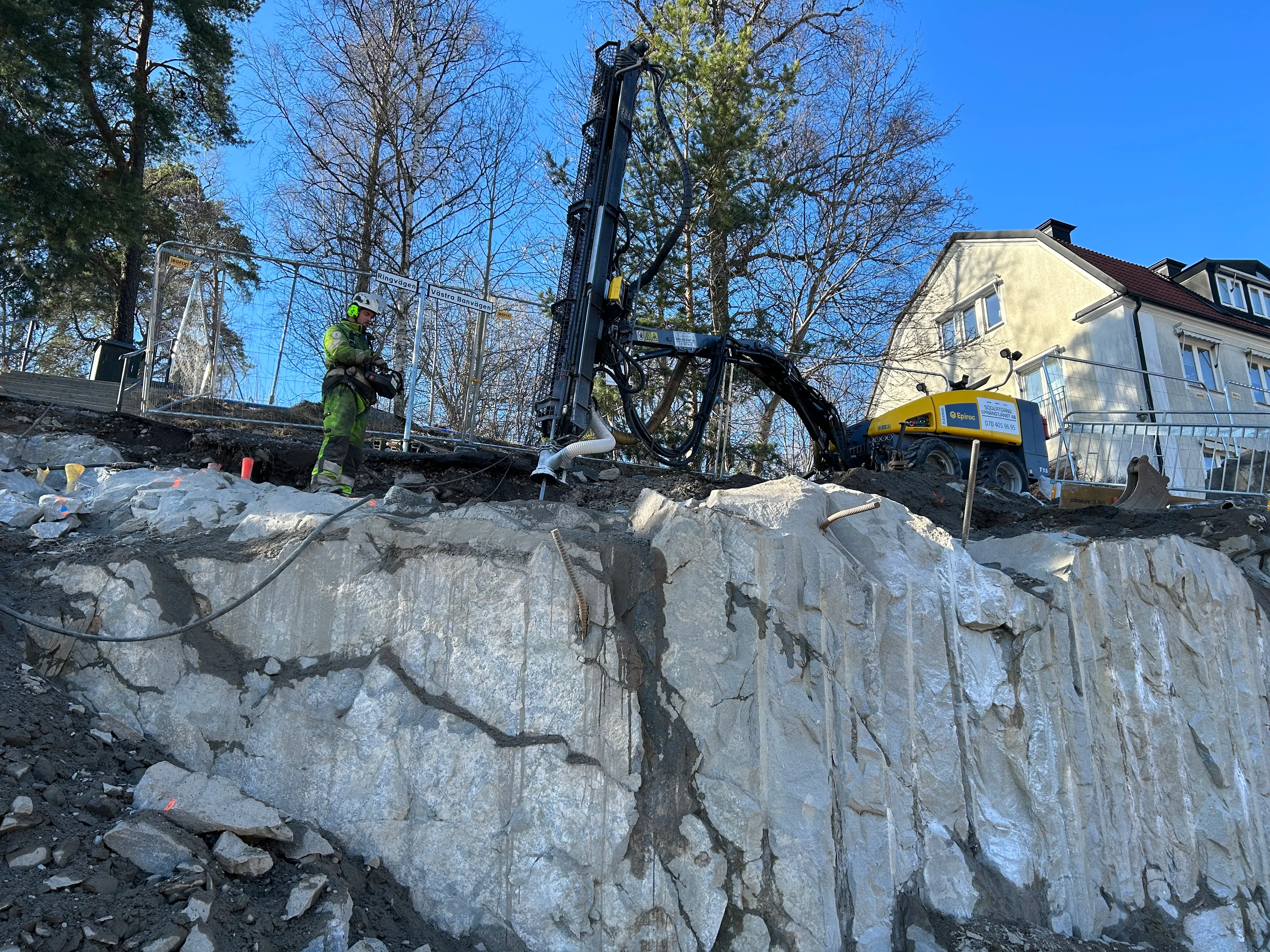 Tomtsprängning av berg vid villatomt med borrigg